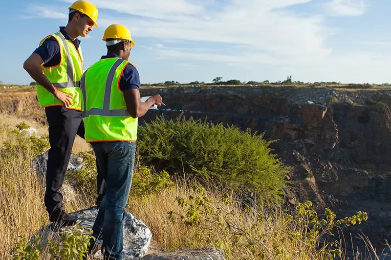 Two people assessing some land